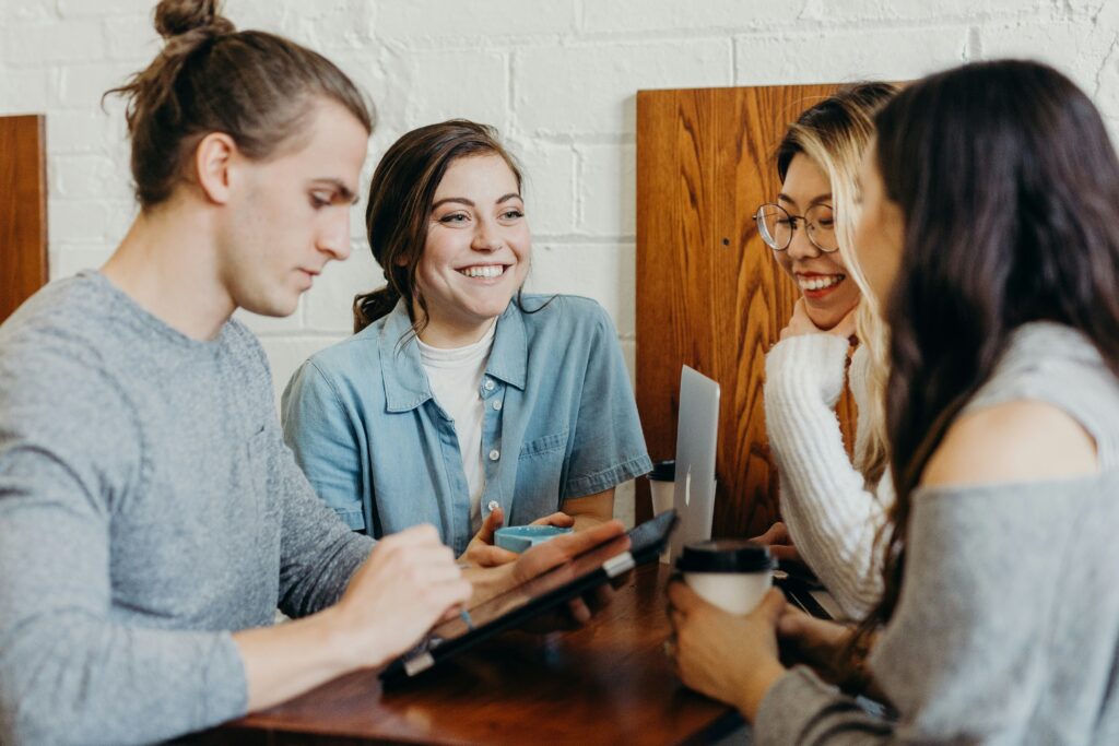 people getting coffee gathered around computer