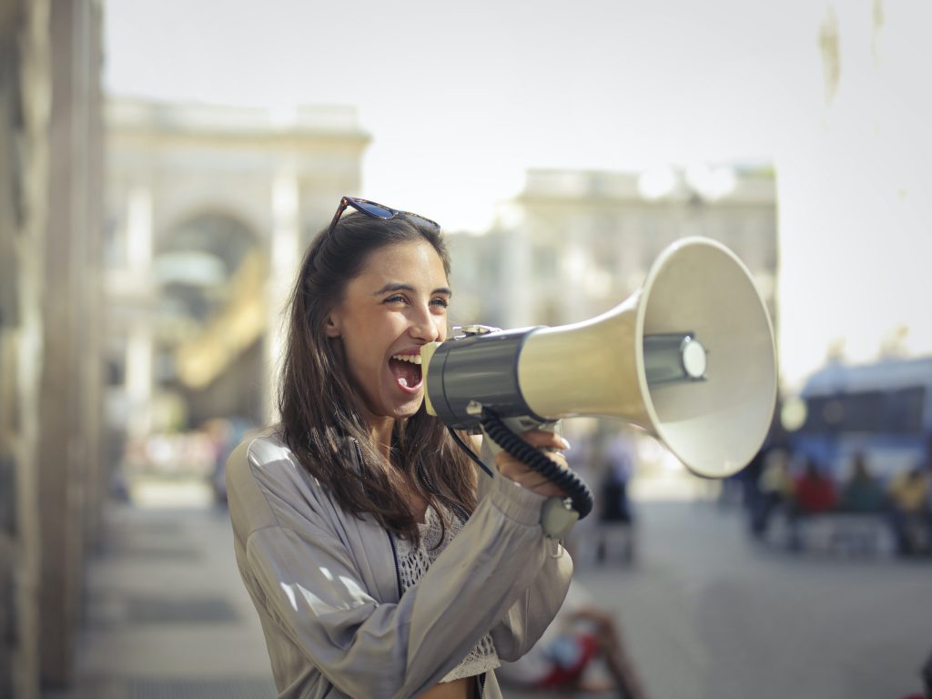 Female with mega phone excited about the new Trellis Live Auction feature