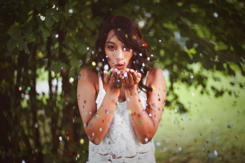 Woman blowing confetti towards the screen